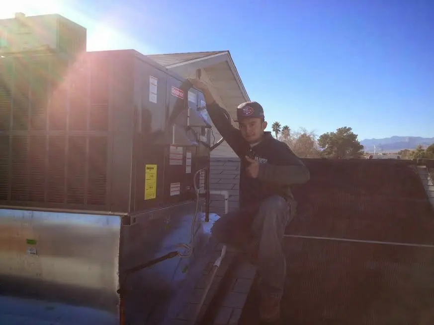 HVAC technician performing AC Tune-Up on a rooftop unit in Boca Raton